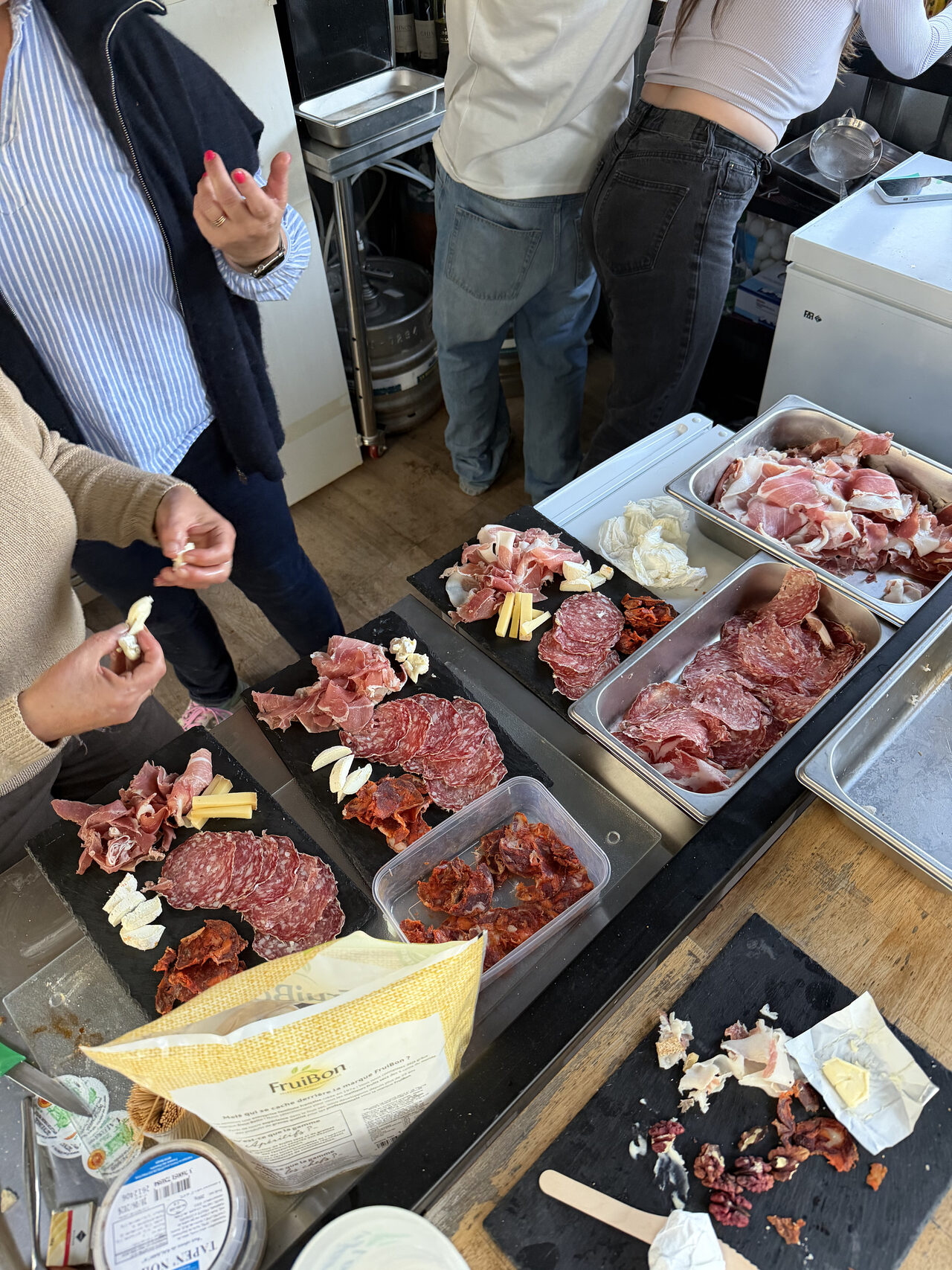Préparation d'une planche de charcuterie : saucisson, jambon et fromage